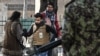 FILE - Taliban fighters walk toward journalists during a protest in Kabul, Afghanistan, Dec. 28, 2021.