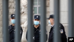 Policemen wearing face masks are seen at No. 2 Intermediate People's Court in Beijing, China, March 22, 2021.