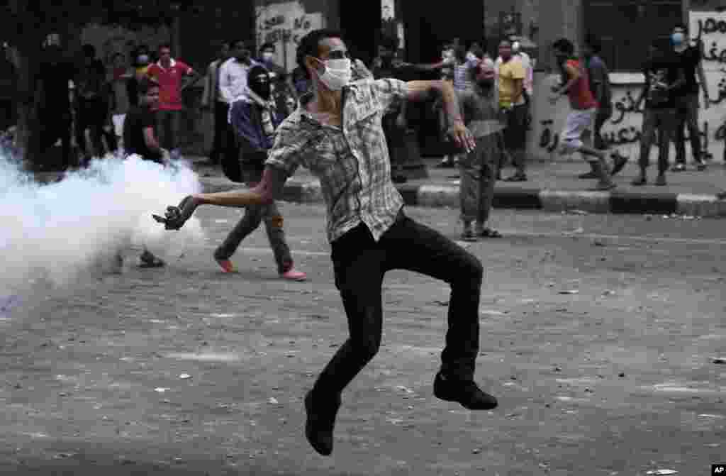An Egyptian protester throws back a tear gas canister toward riot police outside the U.S. embassy in Cairo, September 13, 2012.