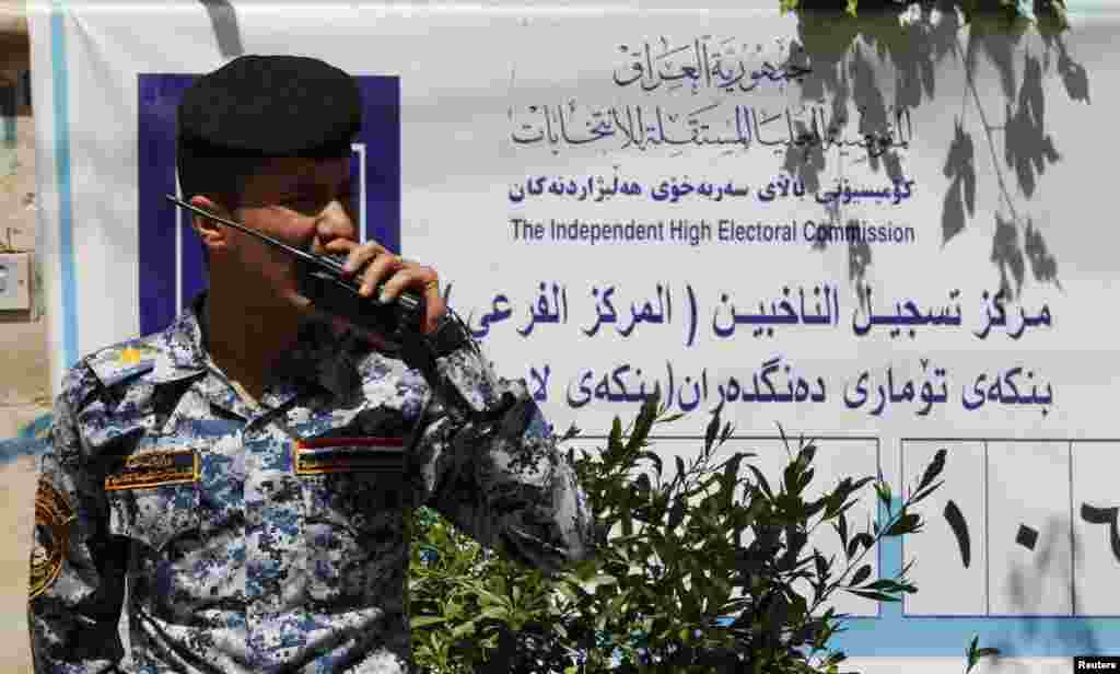 Seorang polisi memberikan instruksi menggunakan &quot;walkie talkie&quot;-nya di sebuah TPS di Baghdad, 19 April 2013. Pemerintah Irak telah memperketat langkah-langkah keamanan di saat negara tengah bersiap menggelar pemilihan pemerintah daerah.