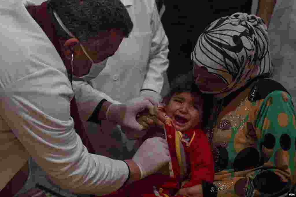 Doctors check the health of a Syrian child at a clinic set up at a refugee camp. Among the most common problems are respiratory diseases such as bronchitis. (John Owens/VOA News)