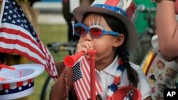 Hana Cho, 8 tahun, dari Pramuka Putri Troop 5665 mencoba meniup terompet sebelum berpartisipasi dalam pawai Hari Kemerdekaan 4 Juli di Santa Monica, 4 Juli 2017.
