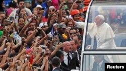 Pope Francis greets the crowd of faithful from his popemobile in downtown Rio de Janeiro, July 22, 2013. 