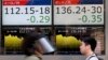 People walk by an electronic board displays exchange rate of euro, left, and British pound at the securities firm in Tokyo, Monday, June 27, 2016.