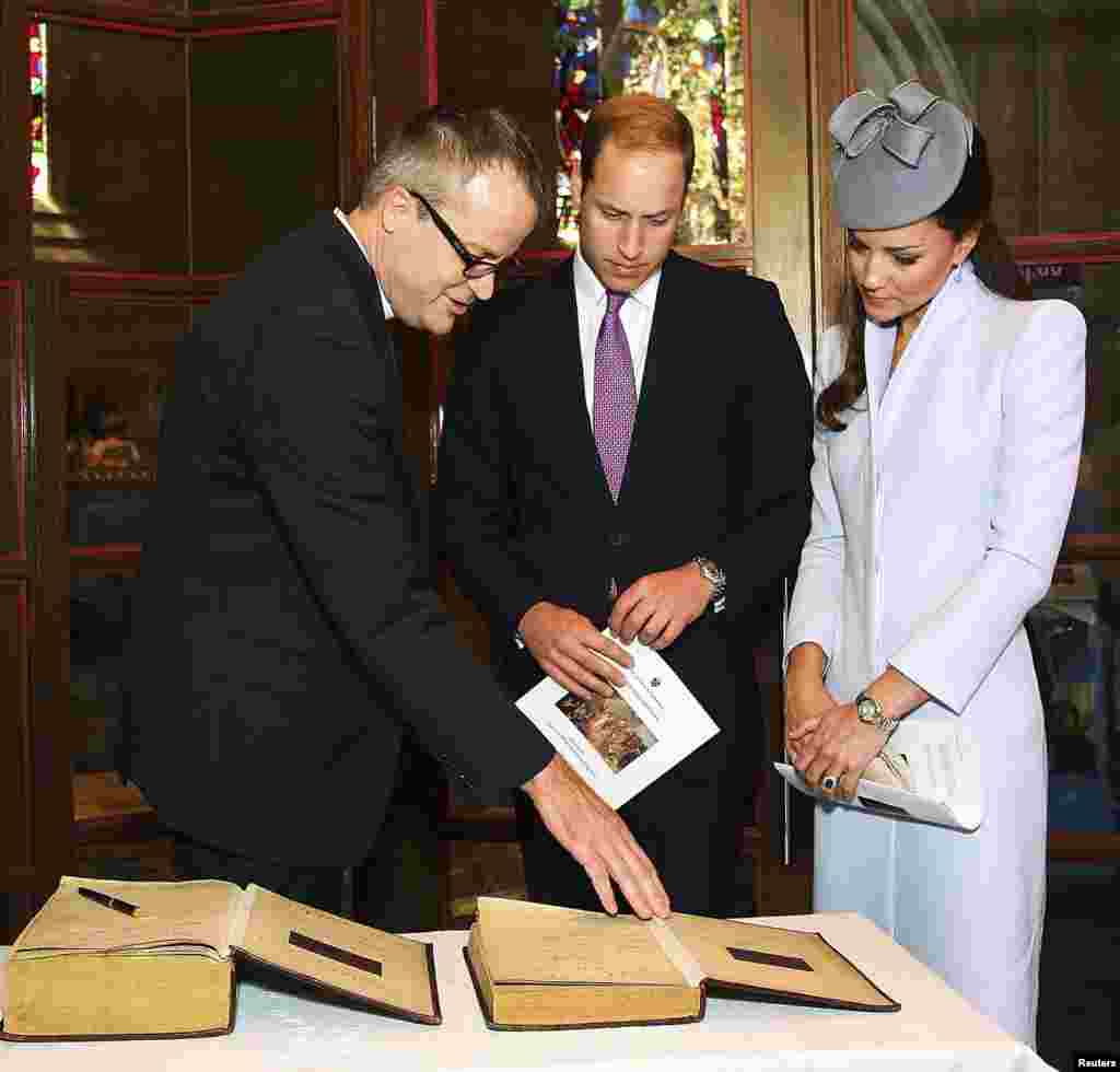 Britain's Prince William and his wife Catherine, Duchess of Cambridge prepare to sign the First Fleet Bible and Prayer Book following Easter Sunday Service at St. Andrews Cathedral in Sydney, April 20, 2014. 