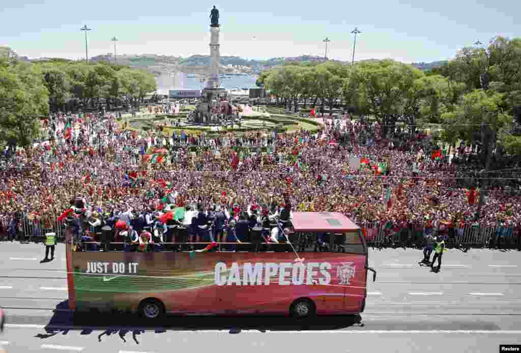 Members of Portugal's winning EURO 2016 team ride in an open bus on their return to Lisbon.