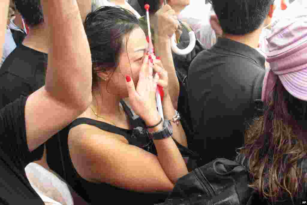 Standing in the rain, Singaporeans watch as the coffin of Lee Kuan Yew passes during the funeral procession at the Padang parade grounds and City Hall, March 29, 2015.