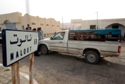 FILE - A van crosses the Tunisian-Libyan border of Dhuheiba, Tunisia, April 21, 2011.
