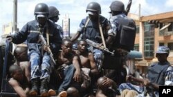 Rioters sit on the back of a police truck after their arrest in Kampala, Uganda, after riots broke out, April 29, 2011
