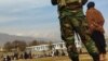 FILE - Taliban security personnel keep watch ahead of the court flogging of women and men at a football stadium in Charikar city of Parwan province, Dec. 8, 2022. 