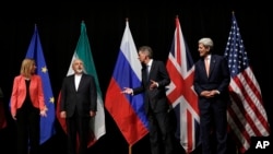Menlu Inggris Philip Hammond (dua dari kanan), Menlu AS John Kerry (paling kanan), dan Perwakilan Tertinggi Uni Eropa untuk Kebijakan dan Keamanan Luar Negeri Federica Mogherini (kiri) dan Menlu Iran Mohammad Javad Zarif di Wina, Austria (Foto: dok). 