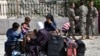 Des réfugiés syriens attendent près de la frontière entre le Liban et la Syrie pour être rapatriés, le 18 avril 2018