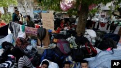 Des migrants reposent sous un arbre sur la Place Victoria à Athènes, en Grèce, le premier mars 2016. (AP Photo/Thanassis Stavrakis)