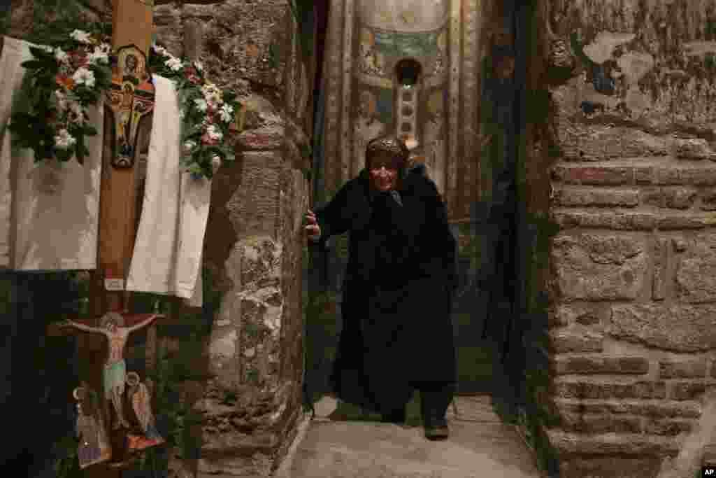 A Kosovo Serb Οrthodox woman attends Easter mass in the monastery of Gracanica during an Easter service, Kosovo, April 16, 2017.
