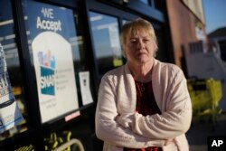 FILE - Terry Work stands outside a store that accepts food stamps in Bon Aqua, Tenn., Jan 29, 2016. Work's 27-year-old deaf son was denied disability payments, meaning he is considered able-bodied. And that means he stands to lose his food stamps, even though she said her son has trouble keeping a job because of his deafness. More than 1 million low-income residents in 21 states could soon lose their government food stamps if they fail to meet work requirements.