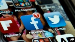 FILE - An iPhone with Twitter, Facebook and other apps, May 21, 2013.