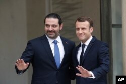 French President Emmanuel Macron, right, poses for photographers with Lebanon's Prime Minister Saad Hariri prior to their meeting at the Elysee Palace in Paris, Saturday, Nov. 18, 2017.
