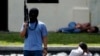 Seorang teroris tiruan memegang senapan di dekat "warga sipil yang ditahan" dalam latihan anti-teror di markas pasukan khusus polisi di Depok, Jawa Barat, 9 Maret 2010. (Foto: REUTERS/Beawiharta)