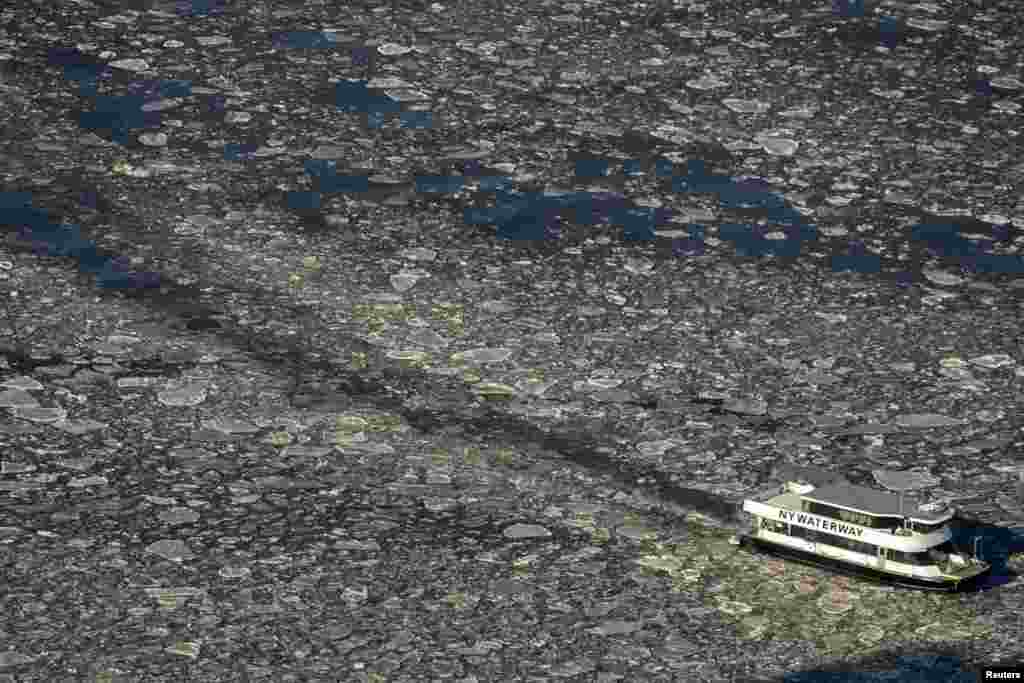 Sebuah kapal ferry meluncur di sungai Hudson antara New Jersey dan Manhattan, New York yang membeku akibat udara dingin.