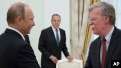 Le président russe Vladimir Poutine, à gauche, et le conseiller américain à la Sécurité nationale, John Bolton, lors de leur rencontre au Kremlin à Moscou, le 27 juin 2018.