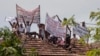 Para terpidana mati melakukan aksi protes di penjara Welikada di Kolombo, Sri Lanka, dengan memegang spanduk dari atap penjara, Jumat, 25 Juni 2021. (AP Photo/Eranga Jayawardena)
