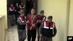 Policiers turcs escortant les deux passeurs à l'origine de la mort du petit Aylan, à Bodrum, en Turquie, le 4 mars 2016.
