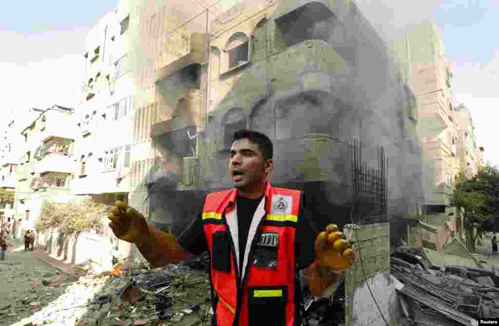 A member of the civil defense reacts after what police said was an Israeli air strike on a house, in Gaza City, July 10, 2014.