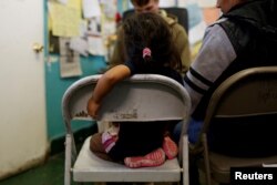 FILE - An undocumented immigrant family from Guatemala talks to a volunteer after their arrival to Announciation House, an organization that provides shelter to immigrants and refugees, in El Paso, Texas, Jan. 17, 2017.