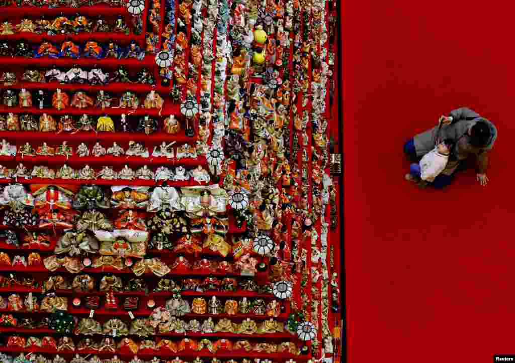 Seorang wanita dan putrinya melihat pameran yang menampilkan 1.605 boneka tradisional Jepang di sebuah acara yang merayakan Hinamatsuri, festival tradisional yang didedikasikan untuk pertumbuhan anak perempuan yang sehat, di Konosu, Prefektur Saitama. (Reuters) 