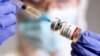 Seorang perempuan memegang botol kecil berlabel stiker "Coronavirus COVID-19 Vaccine" dan jarum suntik medis dalam ilustrasi ini diambil 30 Oktober 2020. (Foto: Reuters)