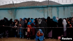 Afghan women stand in line to vote at a polling station in Kabul, April 5, 2014.