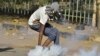 Seorang warga Sudan mengambil kaleng gas air mata dalam bentrokan yang terjadi antara para pengunjuk rasa dan polisi dalam aksi protes menentang kudeta militer, di Khartoum, Sudan, pada 4 Januari 2022. (Foto: AFP)