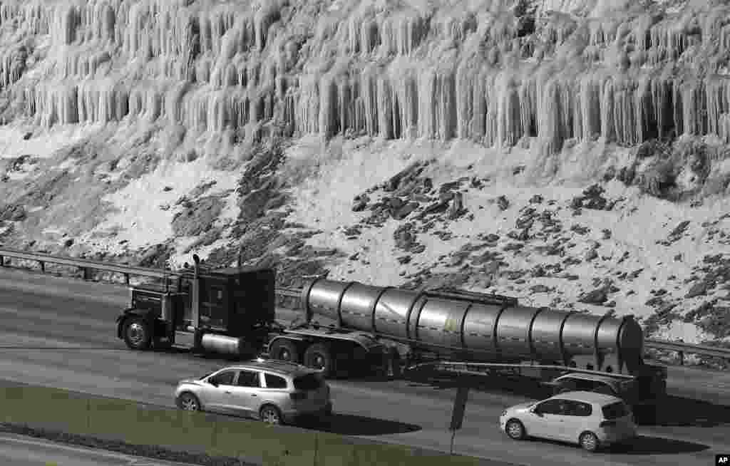 Traffic moves south on I-75 past a hill covered with ice in Covington, Kentucky, USA, where temperatures remain in single digits.