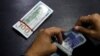 FILE - A currency trader counts Pakistani rupee notes as he prepares an exchange for U.S. dollars in Islamabad, Pakistan, Dec. 11, 2017. 