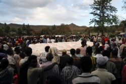 Des personnes font la queue pour recevoir des dons alimentaires, dans un abri temporaire pour les personnes déplacées par le conflit, dans la ville de Shire, dans la région de Tigray, en Éthiopie, le 15 mars 2021.