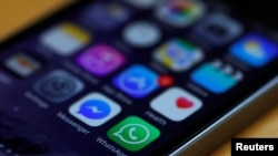 FILE - WhatsApp and Facebook messenger are among app icons are seen on an iPhone.