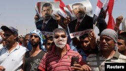 Ribuan pendukung Presiden Morsi berdemonstrasi di depan gedung di mana Morsi ditahan oleh pihak militer, Minggu (7/7). 