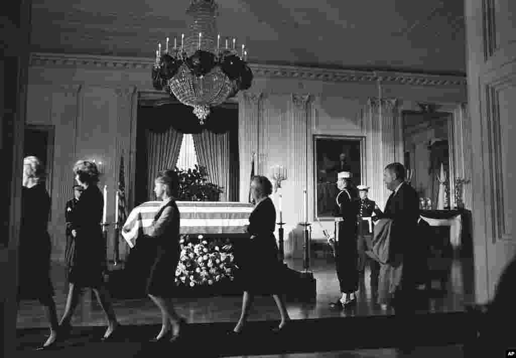 Members of the White House staff file past the body of John F. Kennedy, lying in repose in a closed, flag-draped coffin in the historic East Room of the Executive Mansion in Washington, Nov. 23, 1963. 