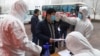 Seorang pekerja migran menjalani pemeriksaan suhu di sebuah pabrik di Zouping, di Provinsi Shandong China, 25 Februari 2020. (Foto: AFP)
