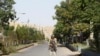 An Afghan security forces personnel stands guard along a road amid ongoing fighting with Taliban fighters in the western city of Qala-i- Naw, the capital of Badghis province, July 8, 2021. 