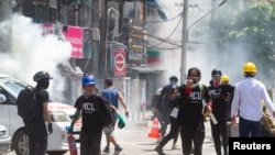 Polisi menembakkan gas air mata pada para demonstran saat mereka melarikan diri \, di Yangon, Myanmar, 8 Maret 2021. (Foto: Reuters)