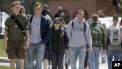 FILE - Students walk across campus at the University of Vermont in Burlington, Vermont. By the end of 2017, according to the Federal Reserve Bank, national student loan debt in the United States was $1.48 trillion.