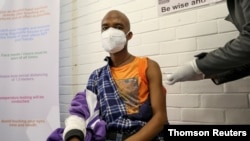 A volunteer receives an injection from a medical worker during the country's first human clinical trial for a potential vaccine against the novel coronavirus, in Soweto, Aug. 13, 2020.