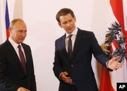 FILE - Austrian Chancellor Sebastian Kurz, right, gestures as he stands with Russian President Vladimir Putin in Vienna, during Putin's visit to Austria, June 5, 2018.