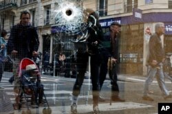 A bullet hole is seen on the window of a cafe located near the area where the assailant of a knife attack was shot dead by police officers, in central Paris, France, May 13, 2018.