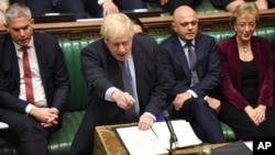 Britain's Prime Minister Boris Johnson speaks to lawmakers inside the House of Commons to update details of his new Brexit deal with EU, in London Oct. 19, 2019. 