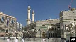 Muslim pilgrims walk outside the Grand Mosque, during the minor pilgrimage, known as Umrah, marking the holy month of Ramadan, in the Muslim holy city of Mecca, Saudi Arabia, April 13, 2021.