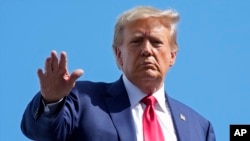 Rais wa zamani Donald Trump akipunga mkono kabla ya kupanda ndege yake ya kibinafsi kwenye Uwanja wa Ndege wa Kimataifa wa Miami, Jumanne, Juni 13, 2023. AP.