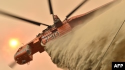 A helicopter drops fire retardent to protect a property in Balmoral, 150 km southwest of Sydney on Dec. 19, 2019. 