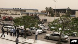 Des passants se rassemblent devant le bâtiment électoral visé par un attentat, à Tripoli, le 2 mai 2018.